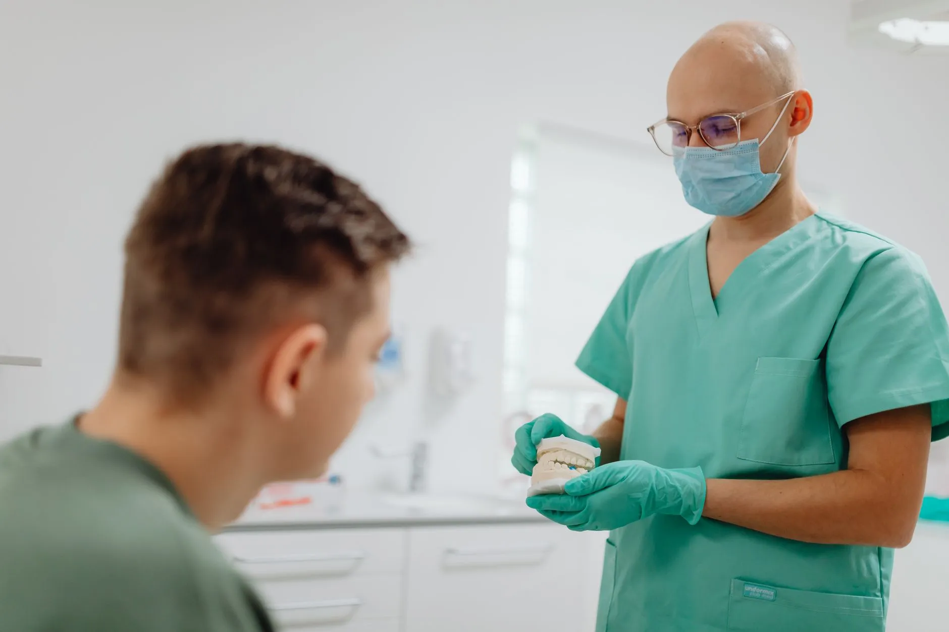 Dentist showing a patient a cracked molar on a screen before recommending a dental crown in Round Rock, TX
