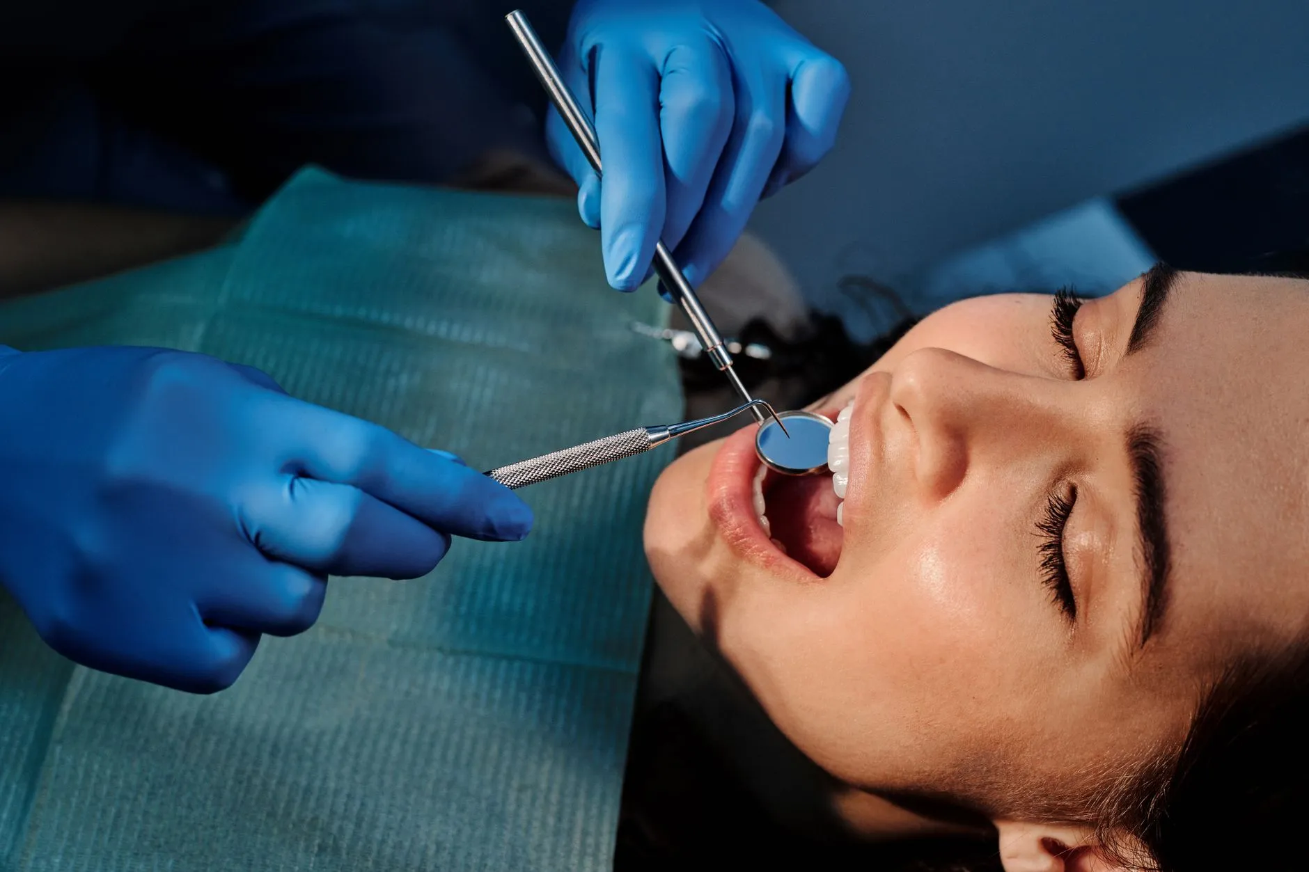 Dental hygienist performing a professional teeth cleaning for a smiling patient at a dental office in Round Rock, TX