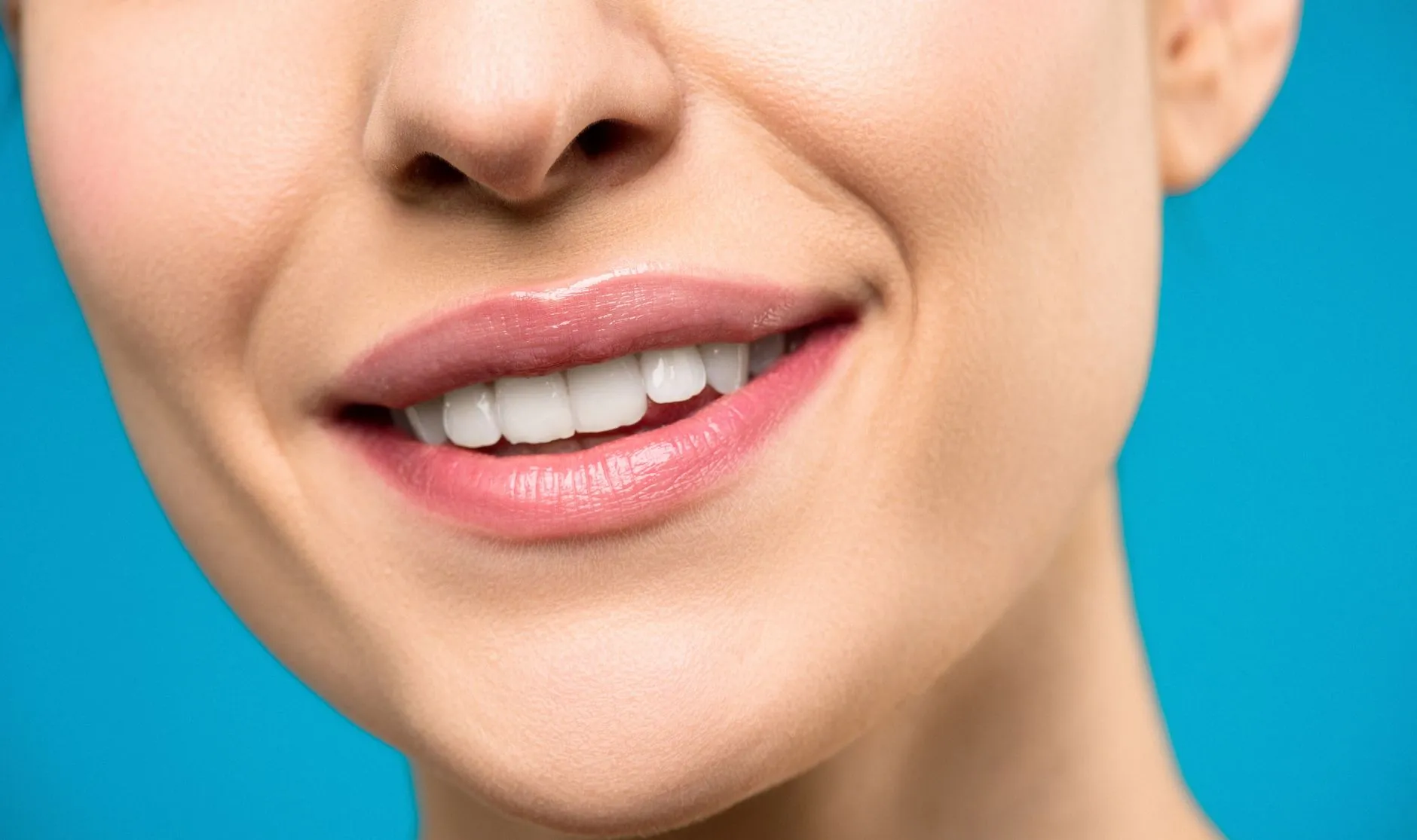 Woman holding a fall coffee drink and smiling with bright white teeth after professional teeth whitening in Round Rock, TX